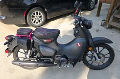 a black motorcycle parked next to a car