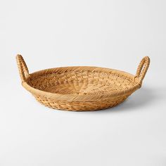 a wicker basket with handles on a white background