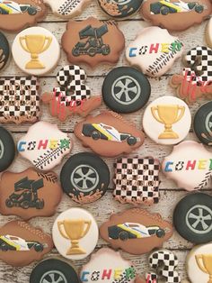 many decorated cookies with racing cars and trophies on top of each cookie, all in different colors