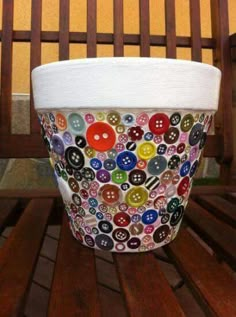 a cup with buttons on it sitting on a bench