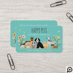 a pair of business cards with dogs and flowers on them, sitting next to some scissors