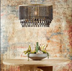 a table with a bowl on it and a chandelier hanging from the ceiling