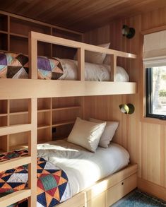 two bunk beds in a room with wooden walls