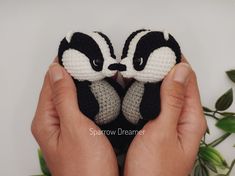 someone holding two small crocheted animals in their hands