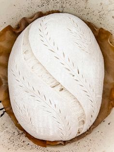 a white bread in a bowl with some brown stuff around it