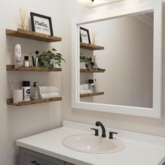 a bathroom sink sitting under a mirror next to a shelf filled with personal care items