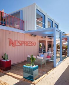 a pink and white building with some plants on the outside patio area next to it