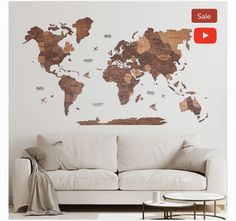 a living room with a white couch and a brown world map wall decal on the wall