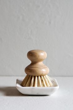 a wooden brush sitting on top of a white plate