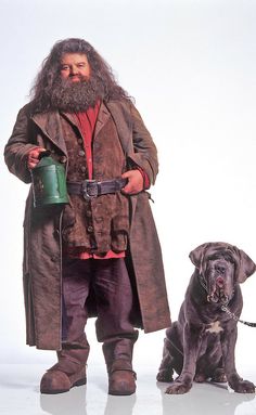 a man with a long beard standing next to a dog and holding a watering can