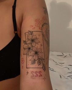 a woman's arm with flowers and numbers tattooed on her left arm, next to a bed