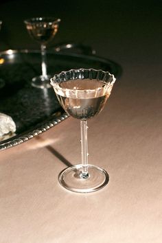 an empty martini glass sitting on top of a table