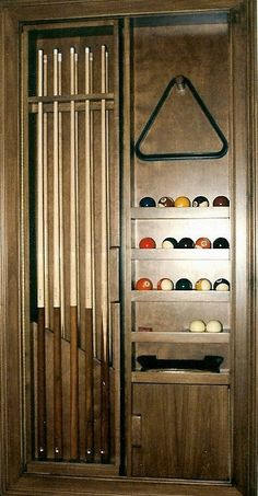 a wooden display case with several different types of balls in it and hanging on the wall