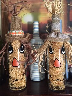 two scarecrows made out of hay sitting on top of a shelf next to each other