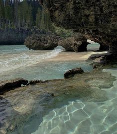 the water is crystal clear and there are some rocks in front of it that look like they have been washed ashore