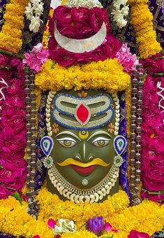 an elaborately decorated mask with flowers around it