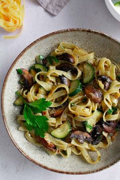 pasta with mushrooms, zucchini and parsley in a bowl on a table