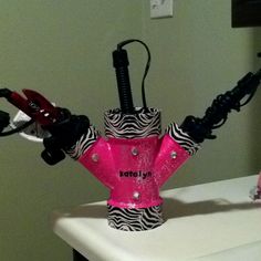 a pink and zebra print toy with two red hair dryers on top of it