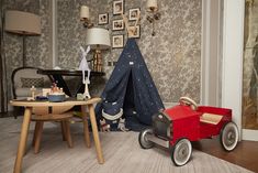 a child's room with a teepee tent and toy cars