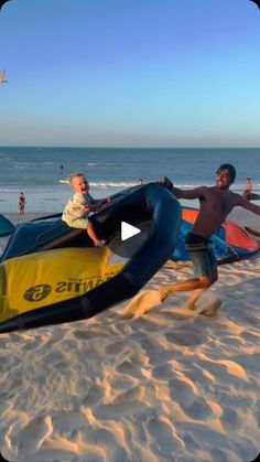 two people on the beach with surfboards and inflatables attached to them