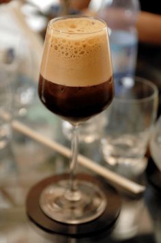 a glass filled with liquid sitting on top of a table