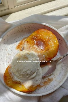 two desserts in a white bowl with spoon on a table next to a window