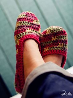 a person's feet wearing knitted slippers