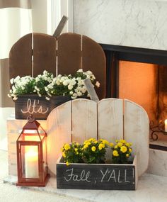 a fireplace with some flowers and a lantern on the mantle next to it that says fall y'all