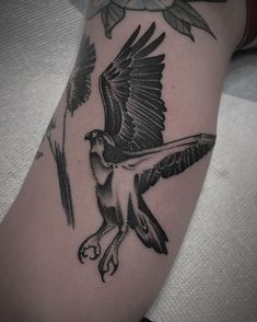 a black and white bird tattoo on the arm