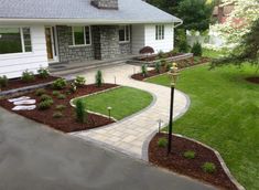 a house with landscaping in the front yard and walkway leading up to the back door