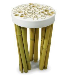 a white table topped with lots of yellow bamboo sticks in front of a white background