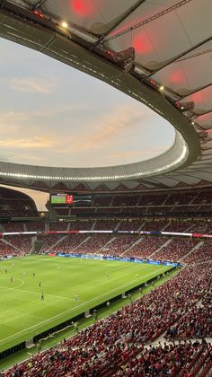 a stadium filled with lots of people watching a soccer game on the field in front of an audience