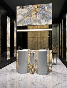 a bathroom with marble walls and flooring next to two large round white tubs