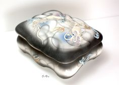 two black and white glass dishes with dragon designs on the sides, one is sitting on top of another