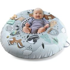 a baby sitting in a blue and white bean bag chair with various animals on it