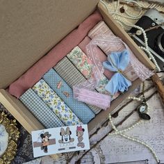 a box filled with lots of different types of fabric next to a clock and other items