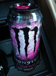 a can of monster energy drink sitting on top of a car console