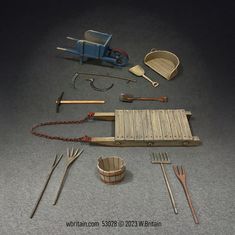 The set includes a blue wheelbarrow, two pitchforks, a scythe, a sickle, a stone boat sled, a winnowing tray, a wooden grain shovel, and a few other traditional farming implements. Miniature Tools, Train Gifts, Farm Tools, Miniature Figurines, Toy Soldiers, Model Building, Shovel, Wizard, No 1