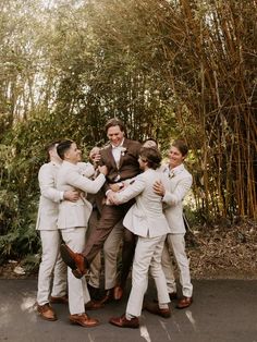 a group of men standing next to each other in front of bamboo trees