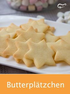 some cookies are on a white plate with candy in the background