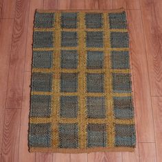 a brown and blue rug on top of a wooden floor