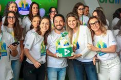 a group of people standing next to each other in front of a green wall with an arrow on it