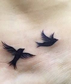 two black birds on the side of a woman's stomach, with their wings spread out