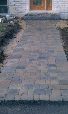 a brick walkway in front of a house