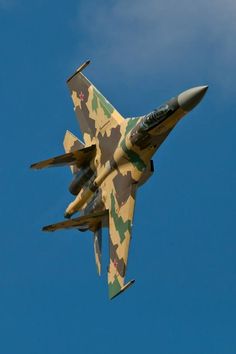 a camouflaged fighter jet flying in the sky