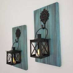 two wall sconces mounted to the side of a wall next to each other