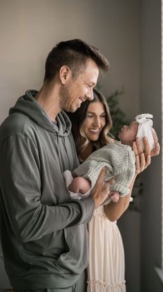 a man and woman holding a baby in their arms