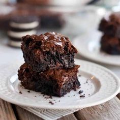 two chocolate brownies stacked on top of each other with one bite taken out of it