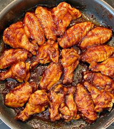 chicken wings are cooking in a skillet on the stove top, ready to be cooked