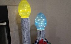 two christmas lights are sitting on top of a tree stump in front of a fireplace